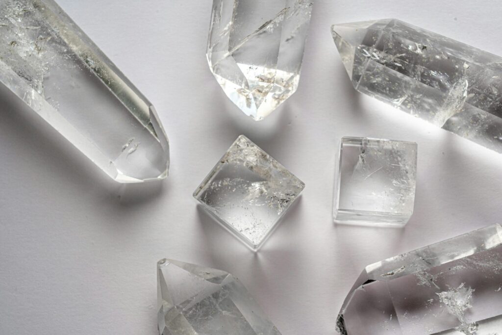 Detailed close-up of various quartz crystals arranged on a white surface.